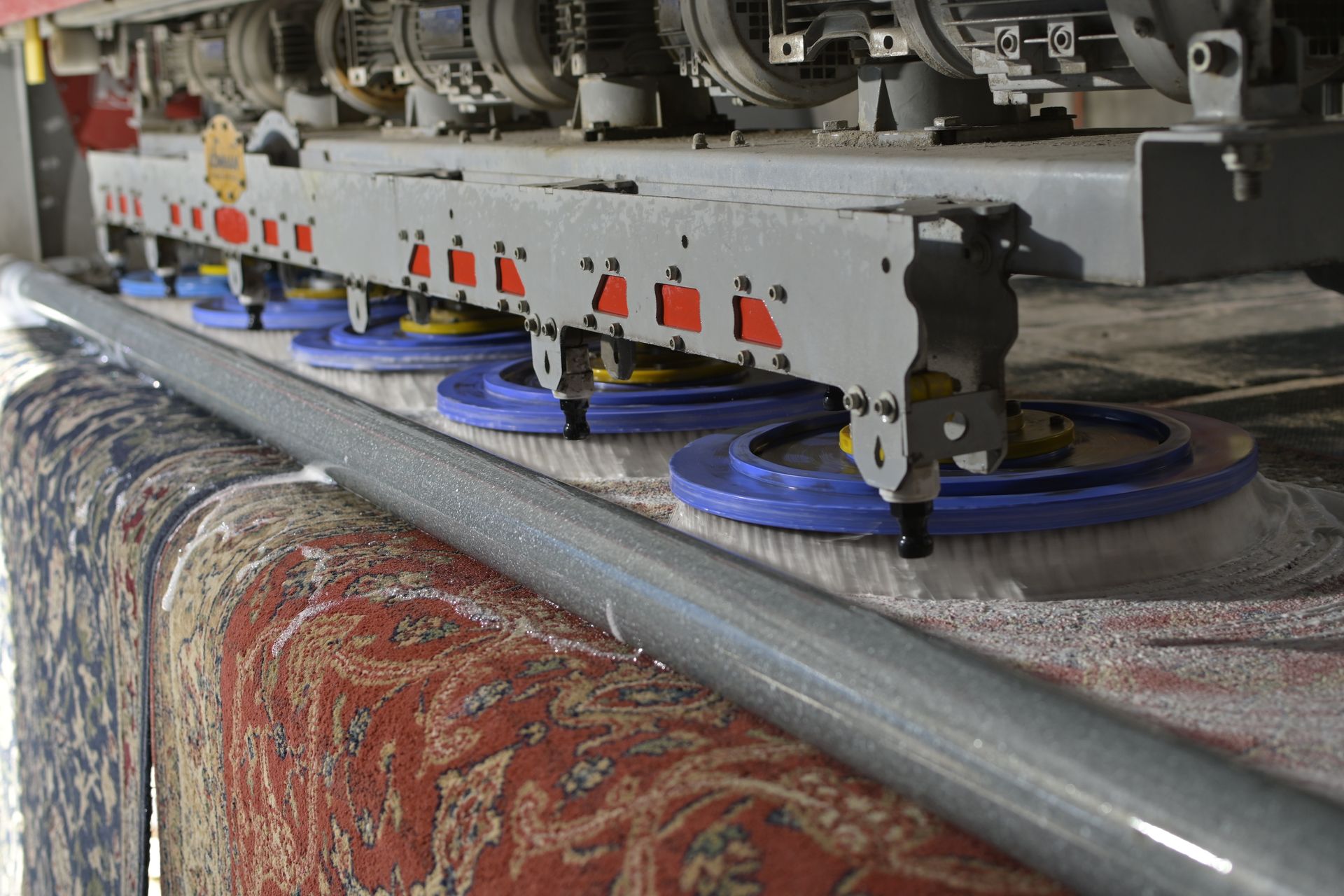 Máquina industrial automatizada lavando una alfombra persa